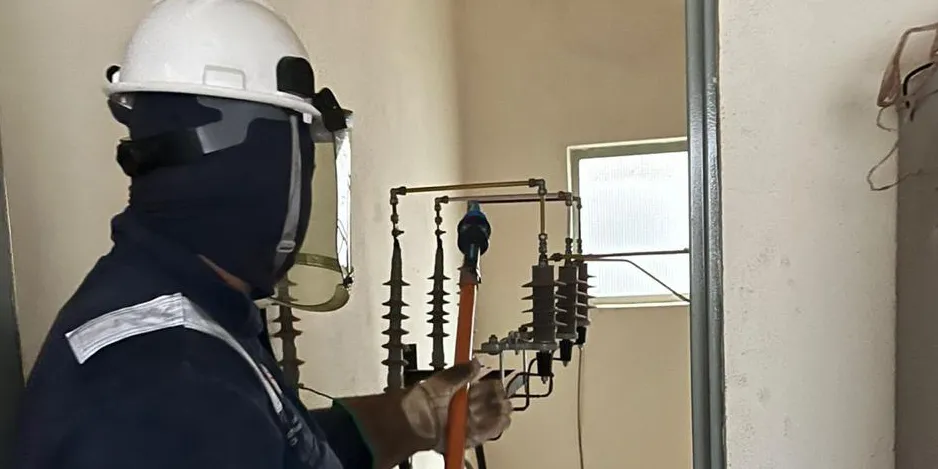 Técnico da Hexa com vestimenta antichama operando equipamento de média tensão